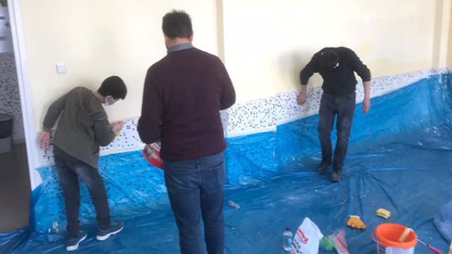 Öğretmenler okul kütüphanesinin duvarlarını boyadı